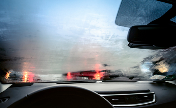 A car driving on a rainy day with the windshield fogging up.