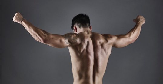 A man standing with his back to the camera during a podcast recording.