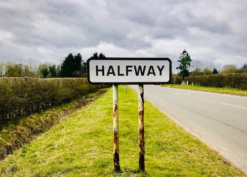 A road sign with the word halfway indicating a midlife shift.