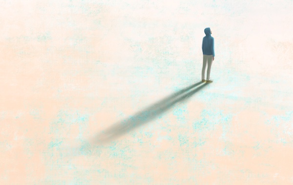 A shadow of a man standing on the ground, reflecting his dreams.