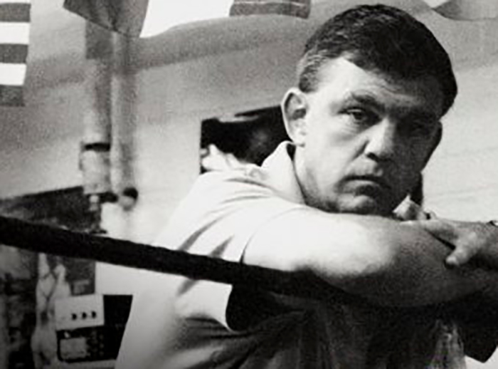 A black and white photo of a man in a boxing ring.