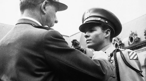 John F. Kennedy receives the Medal of Honor from a soldier.