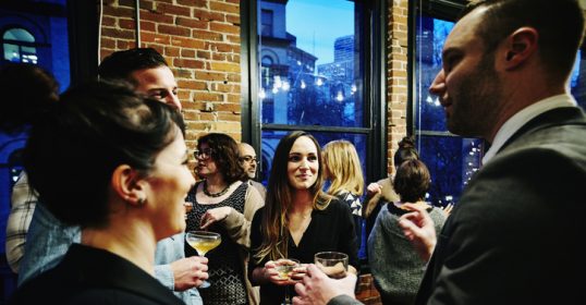 A group of people engaging in small talk at a cocktail party.