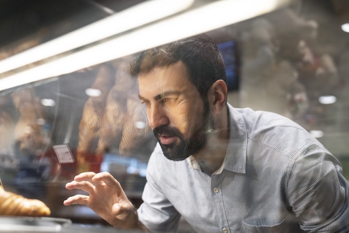 A man with self-control examines bread in a bakery.