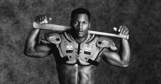A black and white photo of a baseball player holding a bat, reminiscent of Bo Jackson.