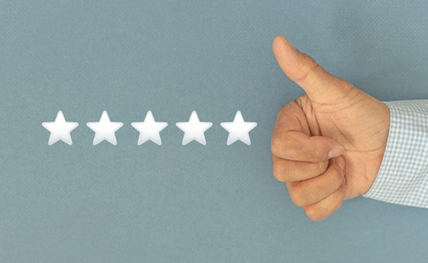 Hand giving a thumbs-up gesture next to five blank stars on a blue background, illustrating how to leave positive reviews.