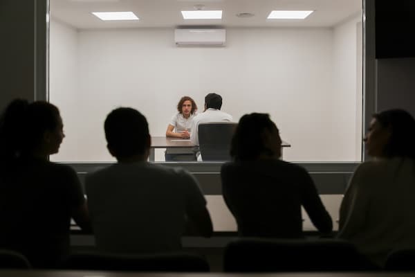 Two people engaged in a conversation about Happiness Studies at a table with an audience in the foreground observing on Podcast 929.