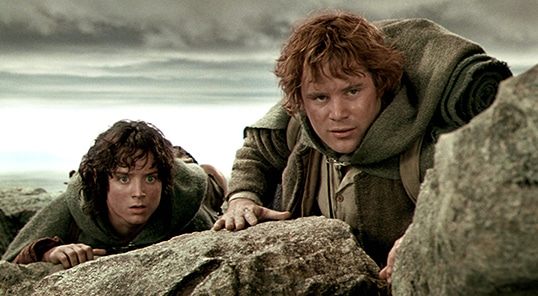 Two individuals, embodying Hobbit virtues, peering over a rocky outcrop with apprehensive expressions.
