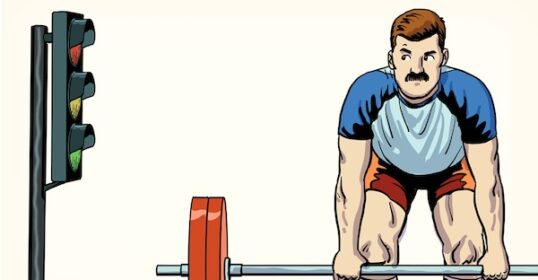 Athlete preparing to perform a deadlift at a traffic signal.