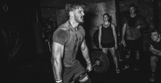 A man performing an exercise by lifting a barbell.