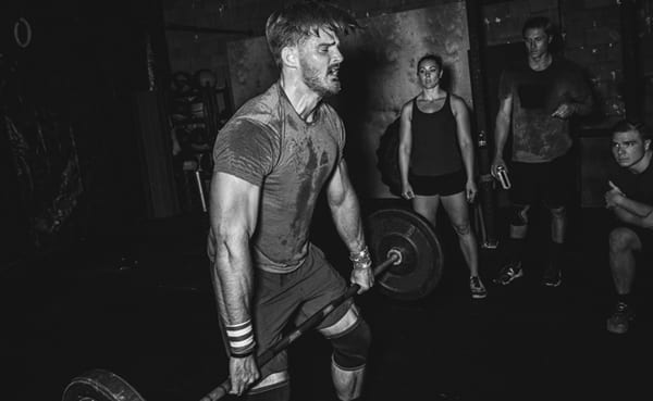 A man performing an exercise by lifting a barbell.