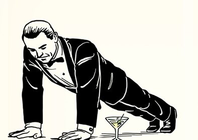 A man in a tuxedo performs a James Bond workout, executing a push-up over a martini glass on the floor.