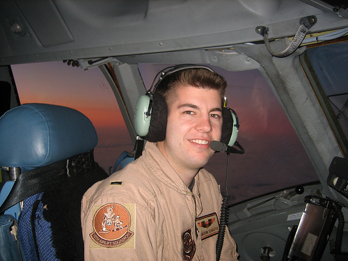 Air force pilot in cockpit with headphones.