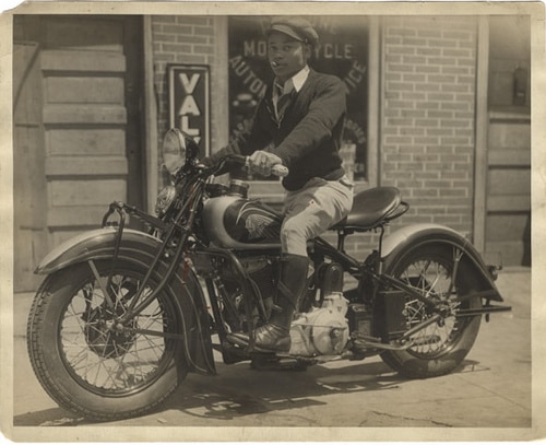 Vintage man sitting on motorcycle.