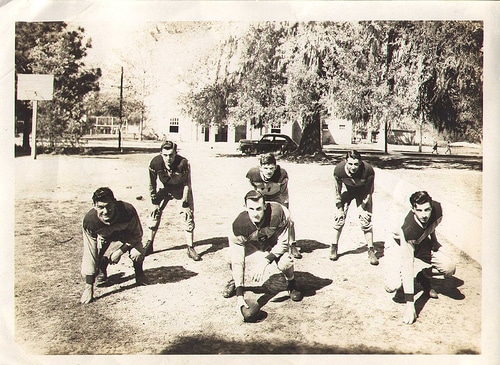 Vintage football team practicing in ground.