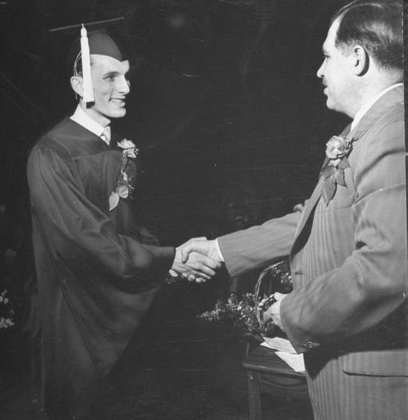 Vintage graduate man accepting diploma degree from professor. 