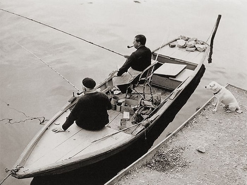 Vintage men fishing sitting in the boat.