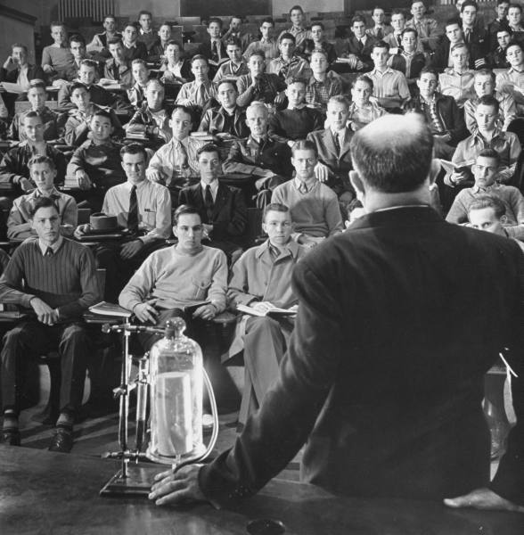 Vintage professor giving lecture to classroom students.