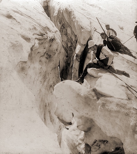 Vintage climbers sitting on mountain peak with smoking pipes.