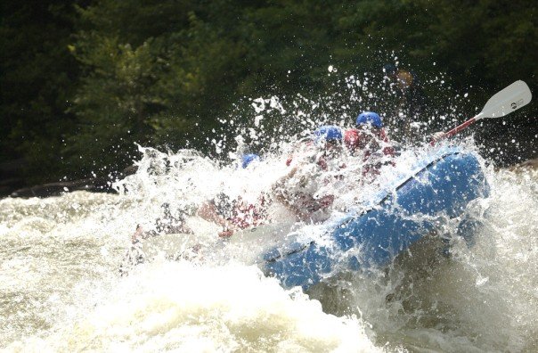 Men enjoying rafting in the river.