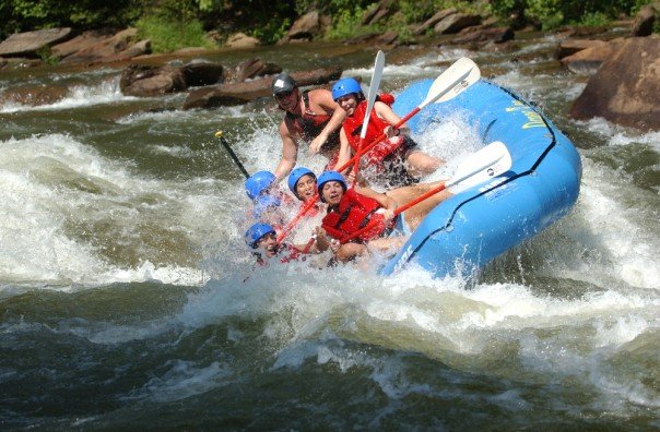 People enjoying rafting in the river. 