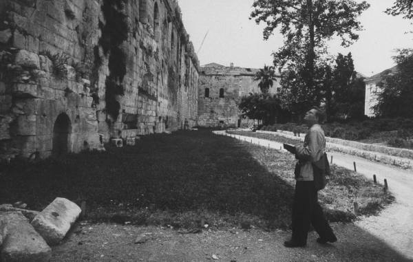 Vintage tourist going toward old fort building. 