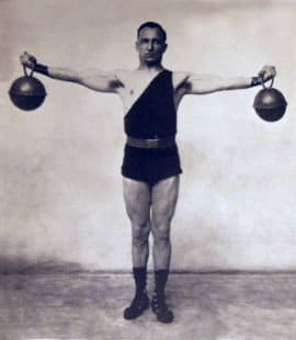 Vintage man holding kettlebells in both hands.