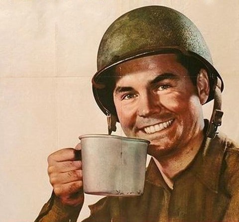 Soldier smiling while holding cup. 