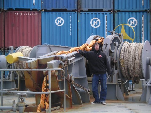 Man giving pose while standing in the freighter ship. 