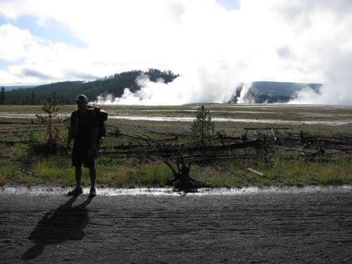 Jeff Rose standing with a backpack in front of hilly area.