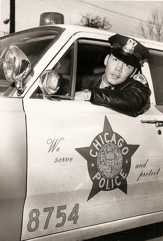 Vintage Chicago police officer looking out from his car's window.