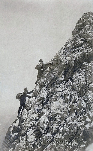 Vintage men climbing the mountain rock.