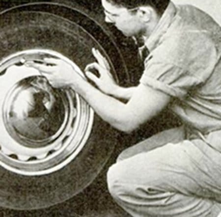 Vintage man working on car tire. 