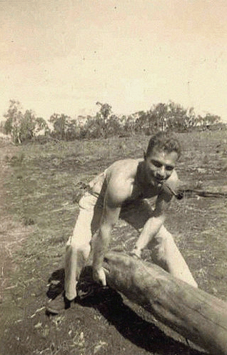 Vintage man lifting wood log in the fields.