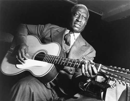 Leadbelly playing with guitar.