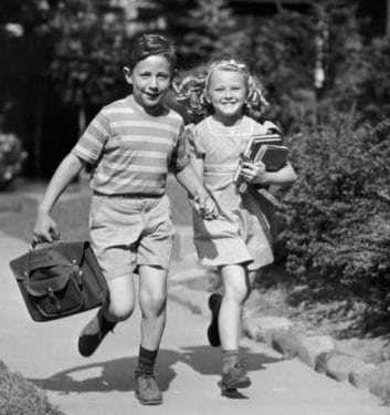 Vintage kids holding hands and running home from school.