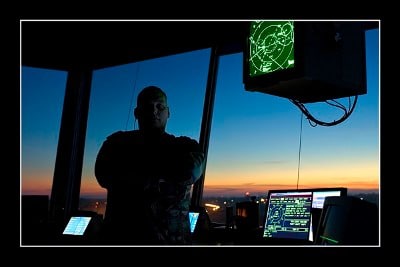 Chris Solomon air traffic controller standing in tower at dusk dawn.