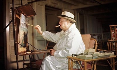 Winston churchill painting in art studio and smoking cigar.