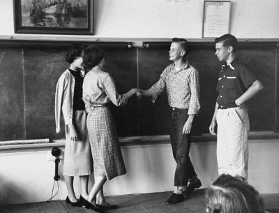 Vintage boys meeting with girls in the classroom for introductions.