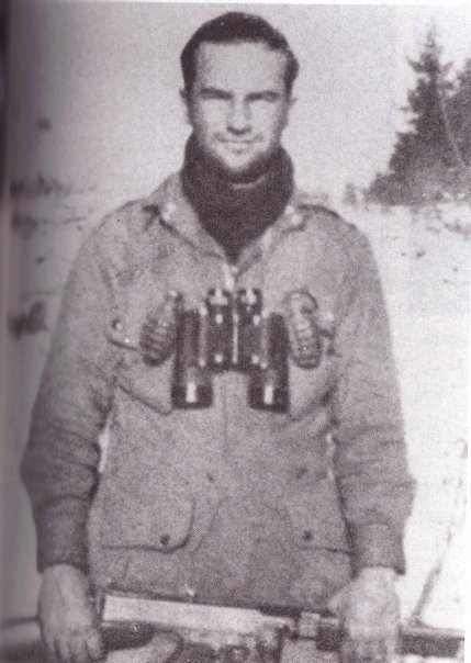 Man having grenades and binoculars on his chest.