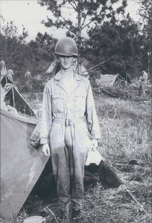 Robert Rader standing in military dress with helmet. 