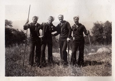 Vintage men hiking with walking sticks in forest.