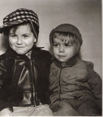 Two young brothers posing while wearing hats.