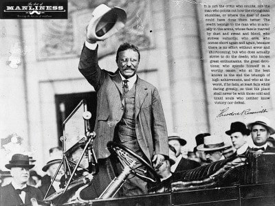Vintage Theodore Roosevelt wearing out his hat and standing in an old car.