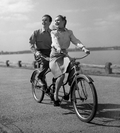 Couple sitting on bicycle and giving smile pose. 