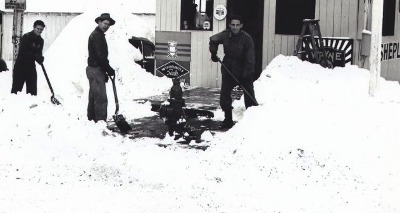 Vintage group of men shoveling snow from sidewalk path.