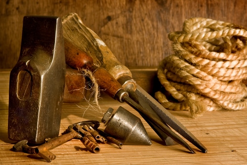 Antique woodworking tools with rope and hammer.