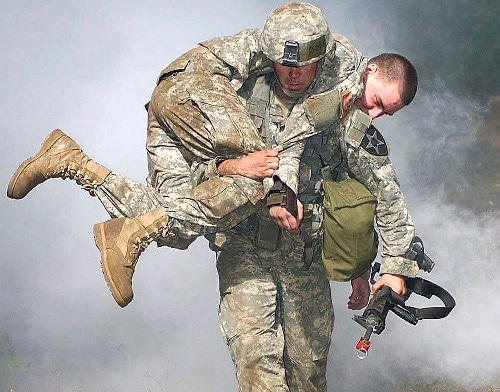 A fireman soldier carrying soldier to save him from fire. 