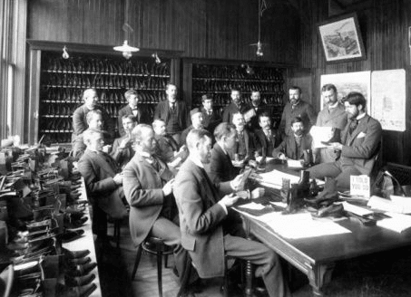 Group of men sitting in shoe store.