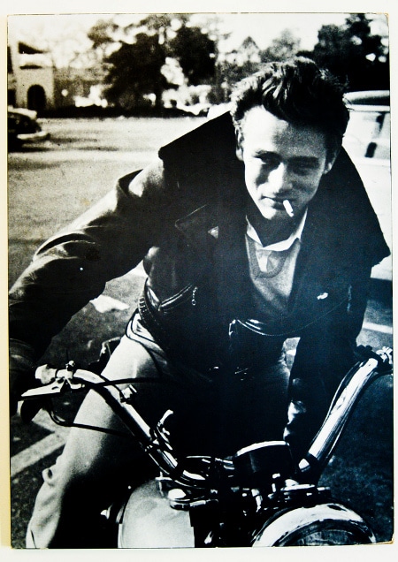 James Dean riding on motorcycle with smoking pose.